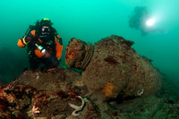 Diver examines cannon on seabed